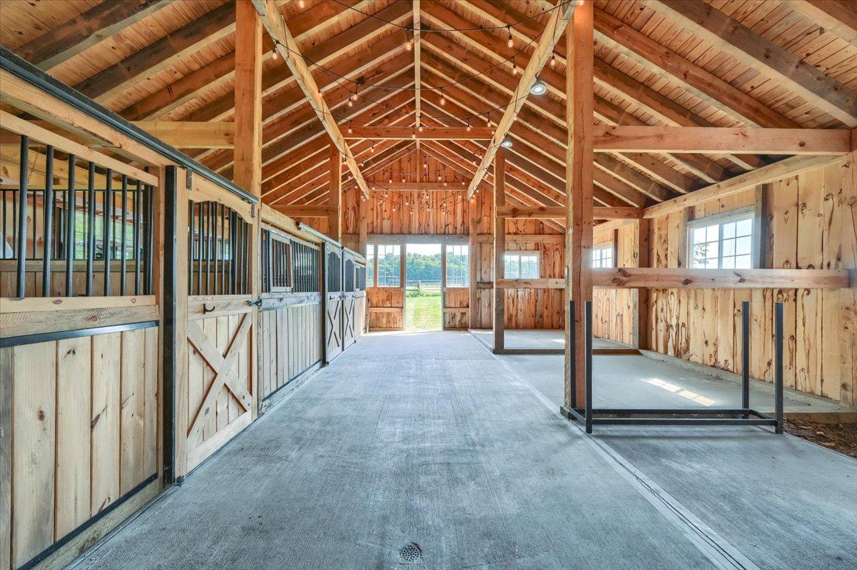 Interior of the red timber-frame barn at The Maple Overlook — small wedding venue reception space with string lights, upstate New York