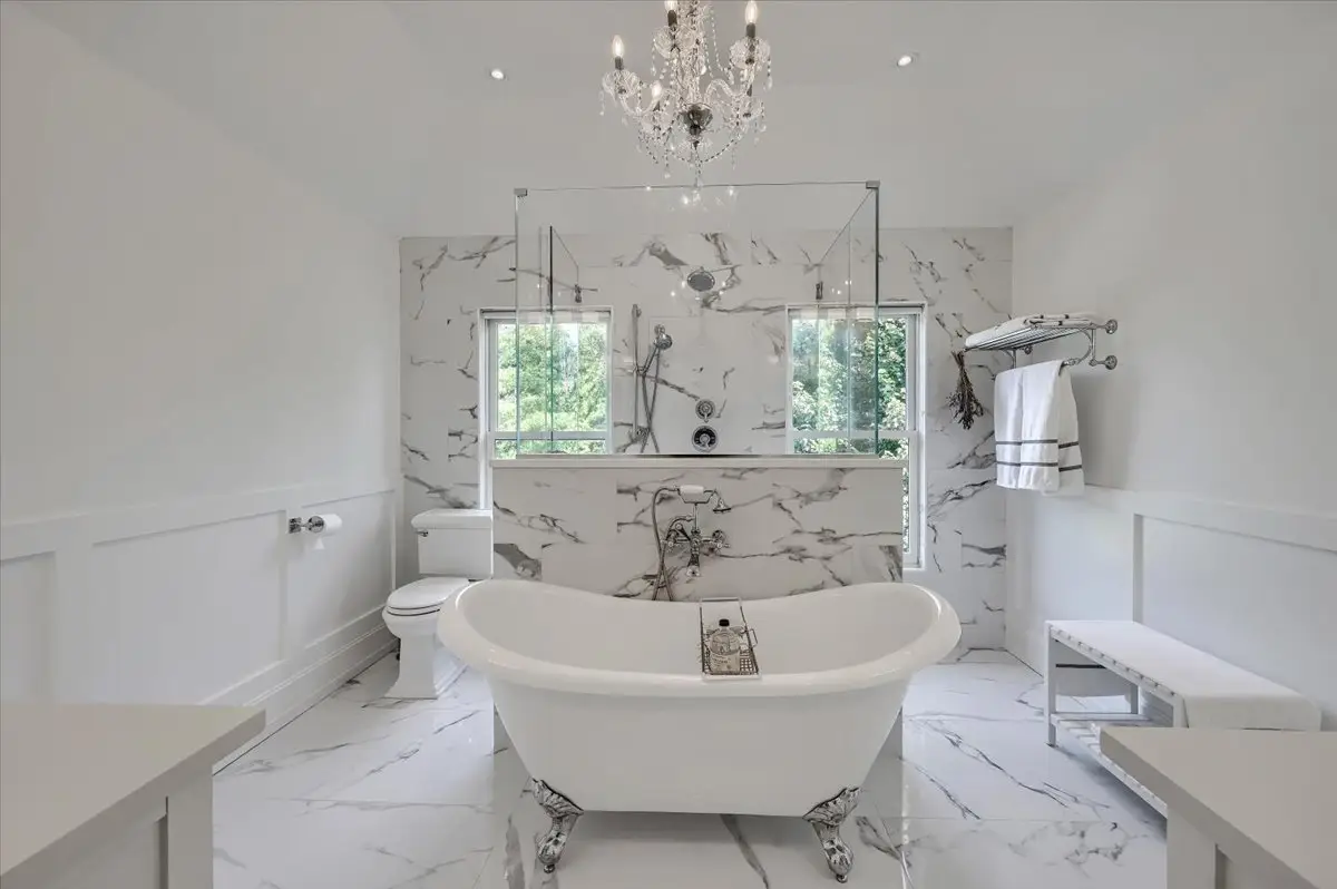 White en-suite bathroom with glass shower and freestanding bathtub