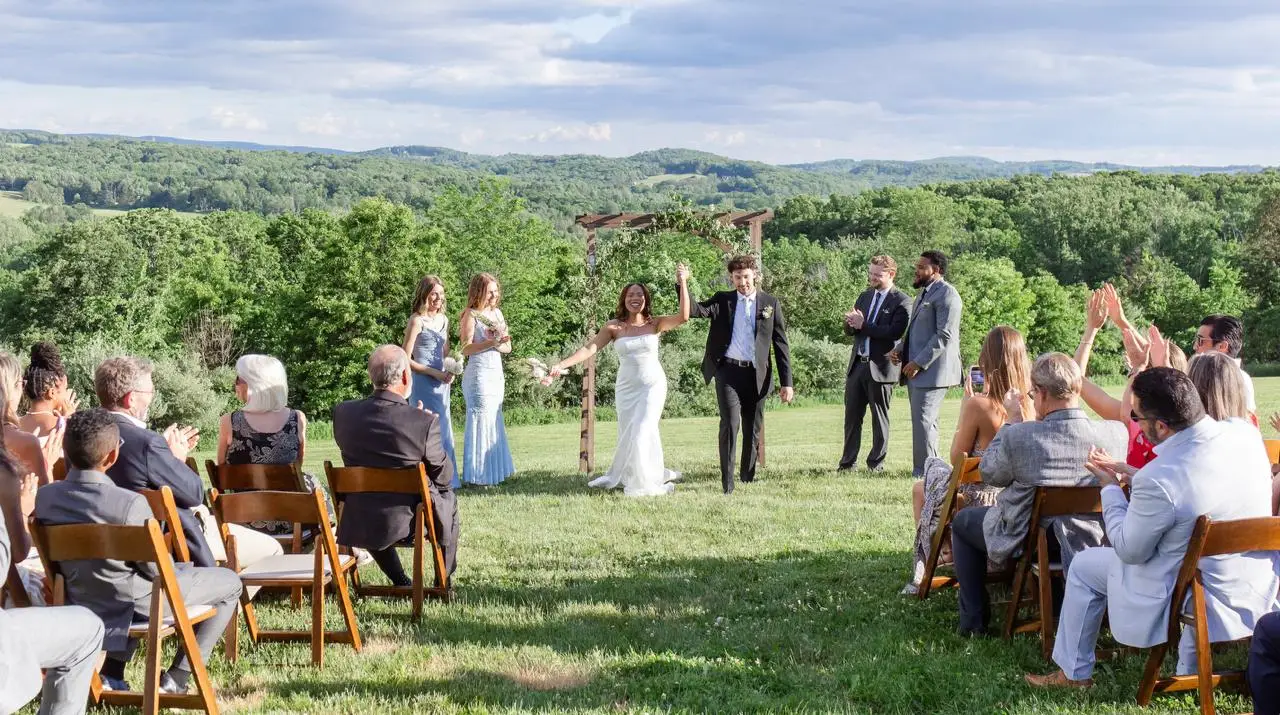 Wedding ceremony exit recessional at The Maple Overlook — couple celebrated by guests on the estate lawn