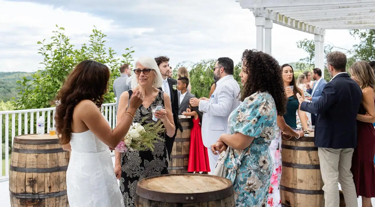 Wedding cocktail hour on the barrel terrace at The Maple Overlook — guests celebrating before dinner