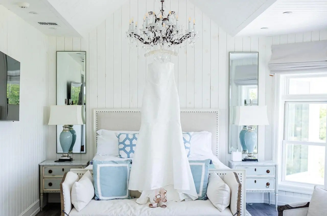 Wedding dress displayed beneath the chandelier in the bridal suite at The Maple Overlook