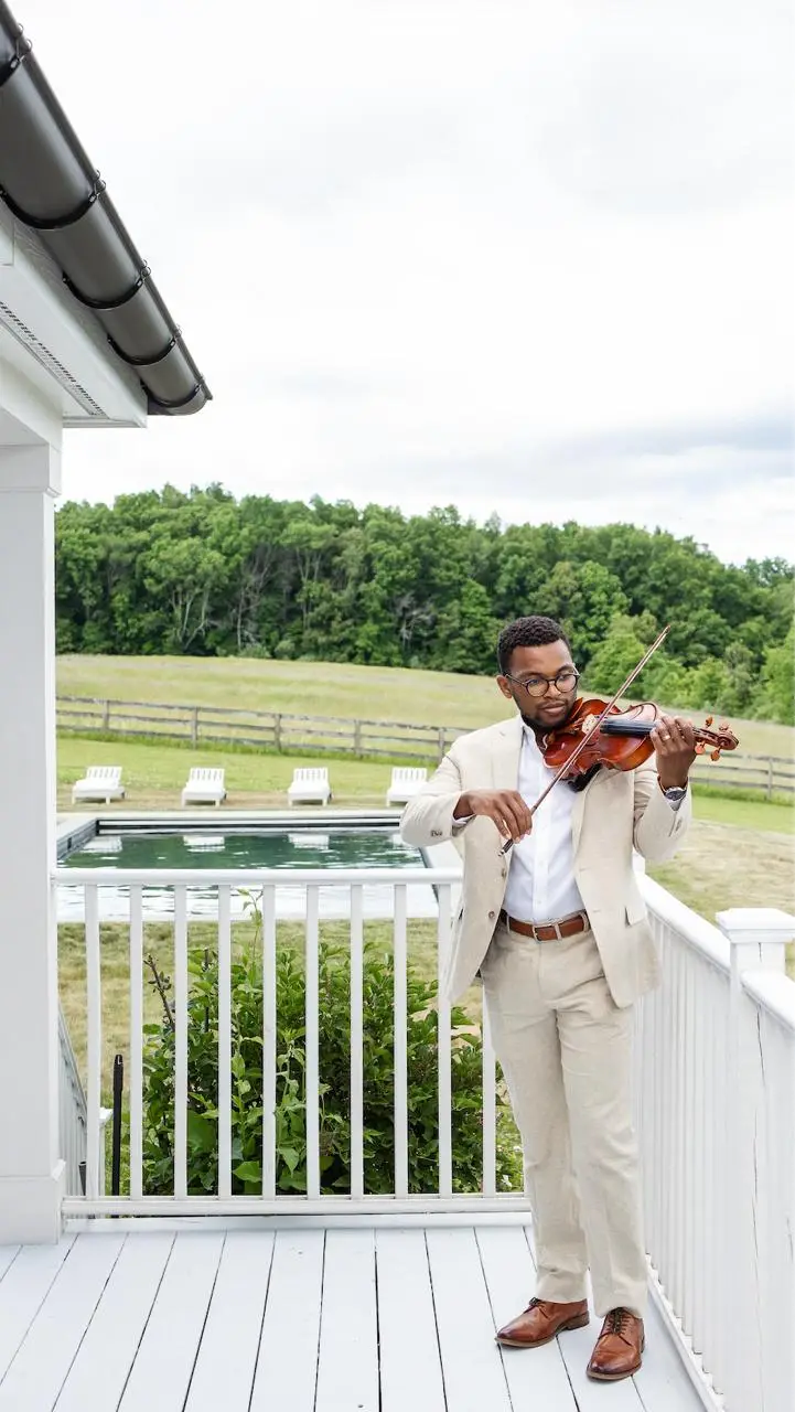 Violinist performing on the wraparound deck at The Maple Overlook during the wedding reception